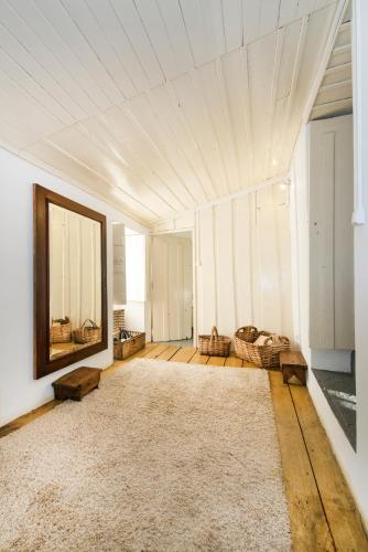 a large living room with a mirror and a rug at O Ze Ja Dormiu Aqui in Celeirós