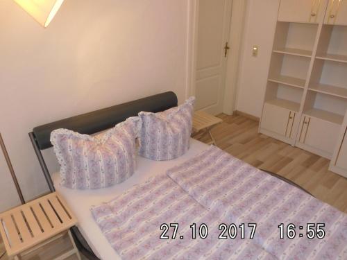 uma cama com duas almofadas num quarto em Ferienwohnung am Schloss em Torgau