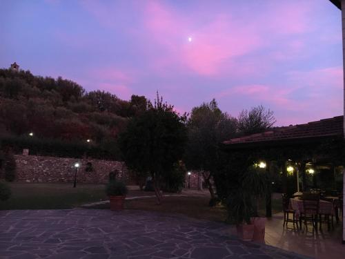 a patio with a table and chairs at night at Relais Borgofasceo in Ortovero