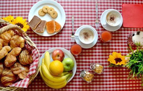 a table with plates of breakfast foods and cups of coffee at Como's Lake Mountains B&B in Cremeno