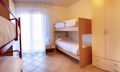 a bedroom with two bunk beds and a window at Como's Lake Mountains B&B in Cremeno