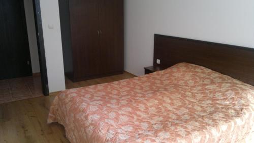 a bedroom with a bed with a orange comforter at Borovets Holiday Apartments - Different Locations in Borovets in Borovets