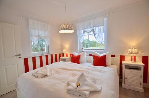 een slaapkamer met twee bedden met rode en witte kussens bij Villa Strandblick 5 in Zingst