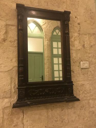 a mirror on the side of a stone wall at Al Bishara Guest House in Nazareth