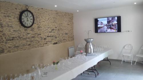 a dining room with a long table with wine glasses at Domaine de la Cour in Sainte-Gemme-dʼAndigné