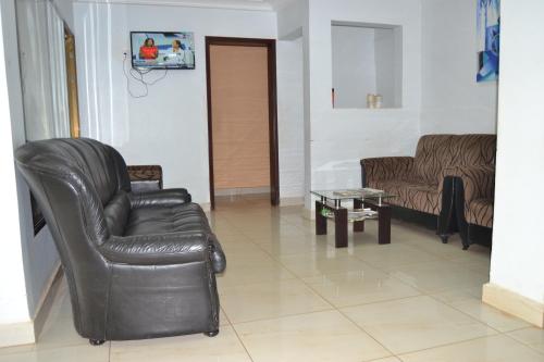 a living room with a leather chair and a table at Massao Palace Hotel in Yaoundé