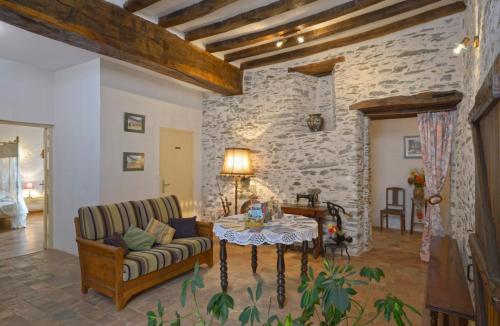 a living room with a couch and a table at Domaine de la Cour in Sainte-Gemme-dʼAndigné