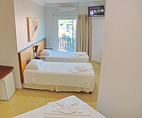Postel nebo postele na pokoji v ubytování Dois Vizinhos Palace Hotel