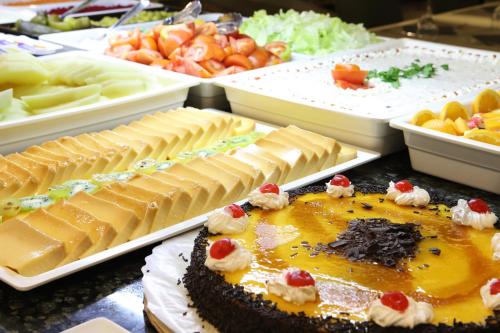 a table topped with different types of cheeses and cakes at Hotel Alameda in Benidorm