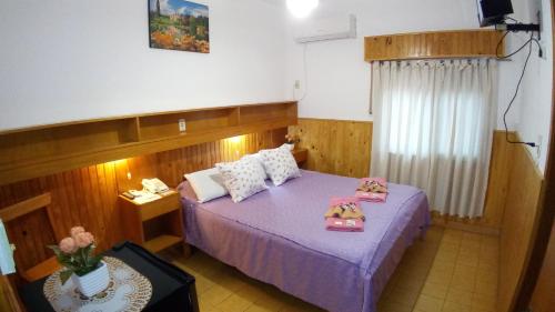 a bedroom with a purple bed with pillows on it at Hotel Ideal in Montecarlo