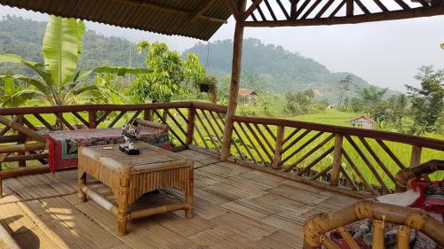 a wooden deck with a table and a bed on it at De Salak Homestay in Bogor