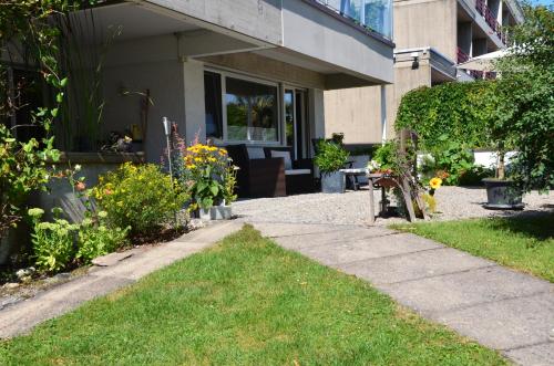a house with a walkway in front of a yard at Lakelodge Romanshorn in Romanshorn