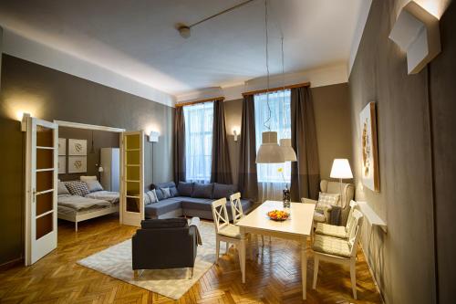 een woonkamer met een bank, een tafel en stoelen bij Logement Sous le Château in Boedapest