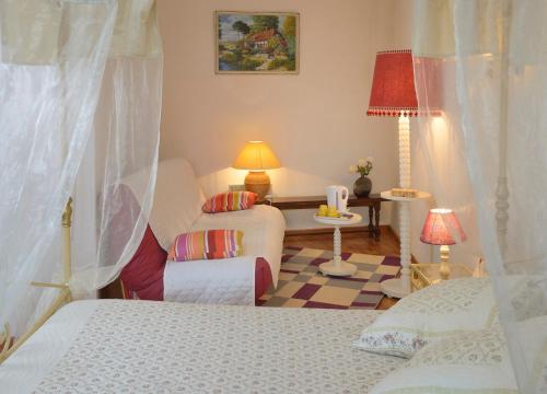 a bedroom with two beds and a chair and a table at Domaine de la Cour in Sainte-Gemme-dʼAndigné