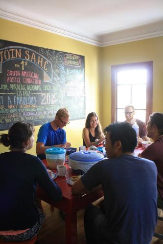 un grupo de personas sentadas alrededor de una mesa en Arequipay Hostel, en Arequipa