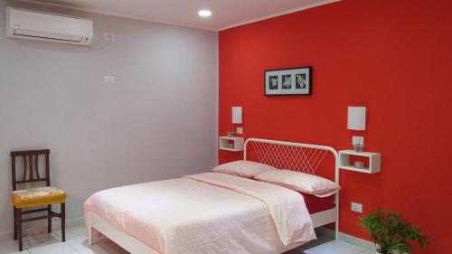 1 dormitorio con cama y pared roja en Magic Napoli Red, en Nápoles