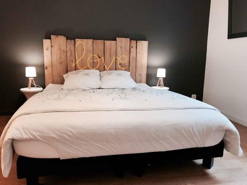 a bedroom with a large bed with a wooden headboard at MyAlsace in Colmar