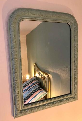 a mirror hanging on a wall with a pillow at MyAlsace in Colmar