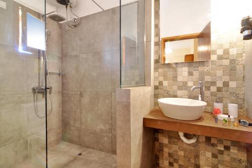 a bathroom with a sink and a shower at Skafonas Apartments in Pelekas