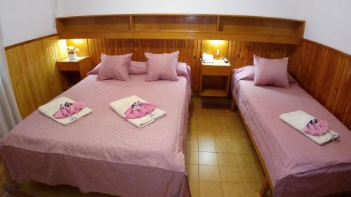 two beds in a room with pink sheets at Hotel Ideal in Montecarlo