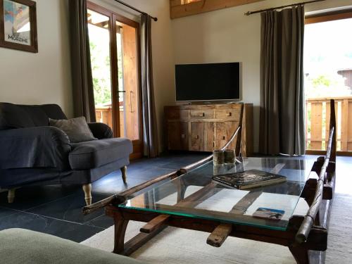 a living room with a coffee table and a tv at Chalet Marmotte 1 in Morzine