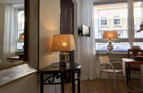 een kamer met een tafel met een lamp en een raam bij Düsseldorfer Domicil Media Harbour in Düsseldorf