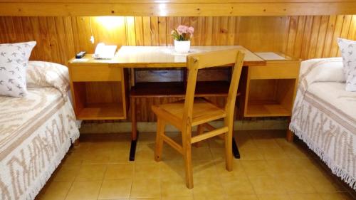 a wooden desk in a room with two beds at Hotel Ideal in Montecarlo