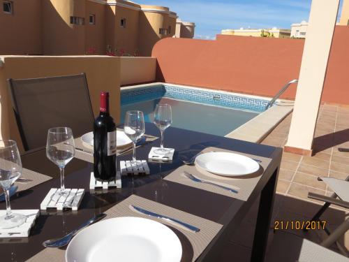 カジャオ・サルバヘにあるCasa Mariben, Vacation Rental home Vv 3 Bedrooms private pool with sea viewsのワイン1本とグラス1杯付きのテーブル