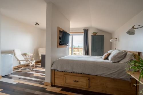 a bedroom with a large bed and a balcony at Le Perchoir in Saint-Félix-d'Otis