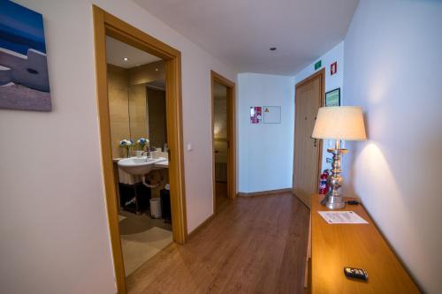 a hallway with a bathroom with a sink and a lamp at Sezimbra in Sesimbra