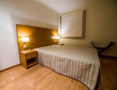 a bedroom with a large bed and a table with lights at Sezimbra in Sesimbra