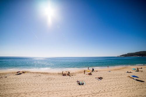 a group of people on a beach near the ocean at Sezimbra in Sesimbra