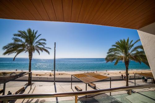 a view of a beach with palm trees and the ocean at Sezimbra in Sesimbra
