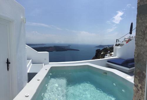 a swimming pool with a view of the ocean at Altana Cliffside Villas in Imerovigli