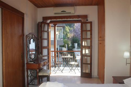 a bedroom with a door open to a patio with a table at Maritsa Lodge in Kakopetria