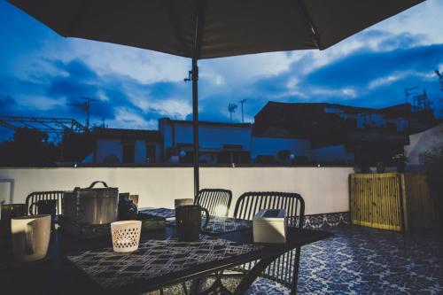 a table with chairs and an umbrella on a patio at Ad Hoc Rooms in Palermo