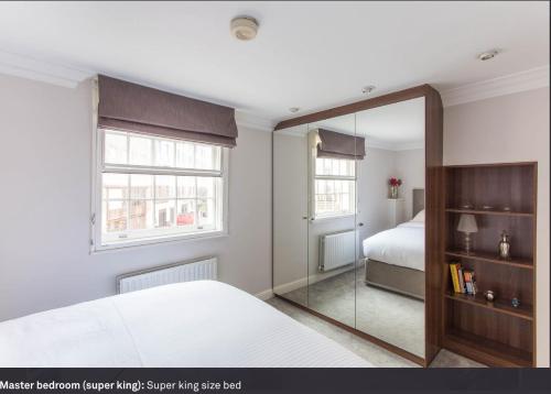 ロンドンにあるHeart of Mayfair - Stunning Apartmentのベッドルーム(鏡、ベッド付)