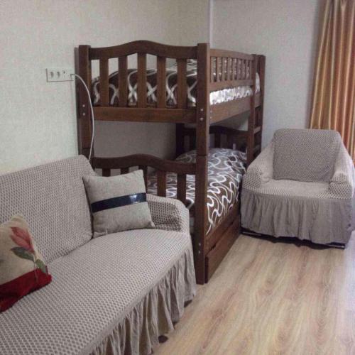 a bedroom with a bunk bed and a chair and a couch at David APT on Bakuriani Orbi Palace in Bakuriani