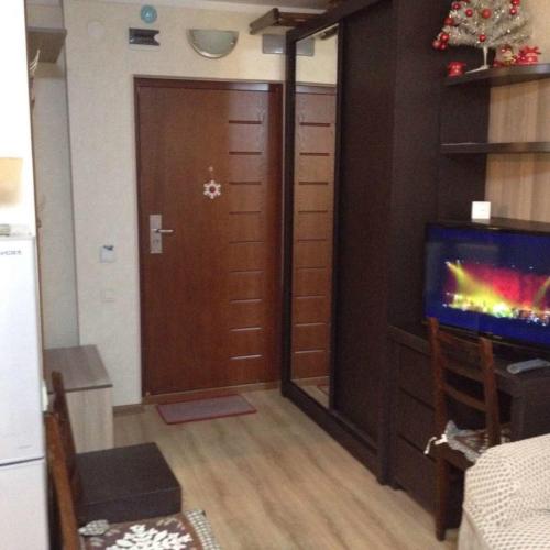 a living room with a door and a tv and a room with a video game at David APT on Bakuriani Orbi Palace in Bakuriani