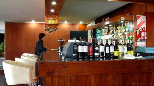a person standing at a counter in a bar at Hotel Rayentray Tehuelche in Esquel
