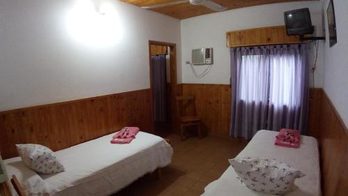 a room with two beds and a tv and a window at Hotel Ideal in Montecarlo