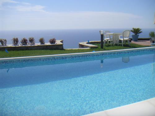 een zwembad met uitzicht op de oceaan bij Villa Vigna in Camporosso