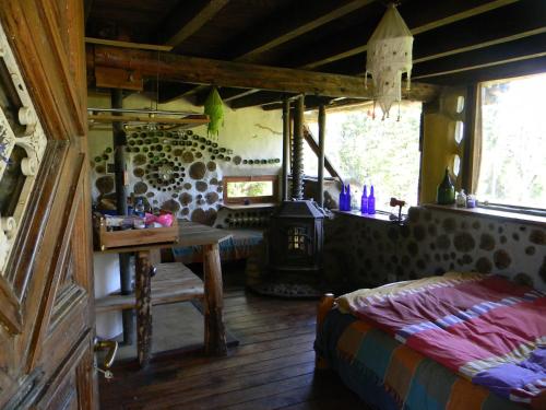 a bedroom with a table and a stove in a room at Manon del Manantial in El Bolsón