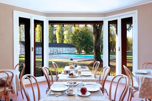 a dining room with tables and chairs and a large window at Agriturismo Tenuta "Il Cigno" in Villanterio