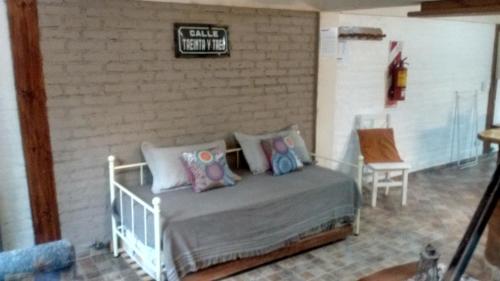 ein Schlafzimmer mit einem Bett und einem Schild an einer Ziegelwand in der Unterkunft Departamentos Lugar de Descanso in El Bolsón