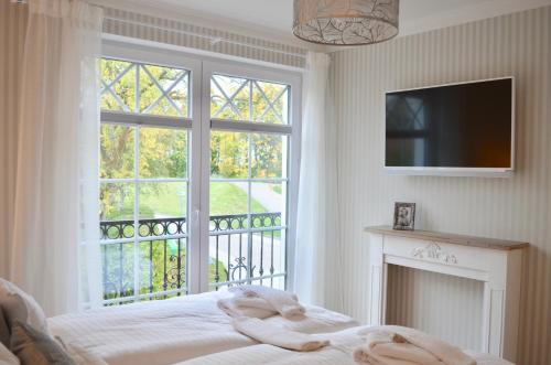 a bedroom with a bed and a large window at Villa Strandblick 3 in Zingst