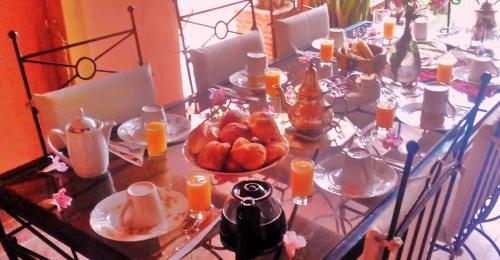 a table with food and orange juice on it at Villa L Walida - Piscine chauffée in Essaouira