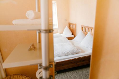 a bedroom with two beds with white sheets and pillows at Landhotel Airport-Inn in Lautzenhausen