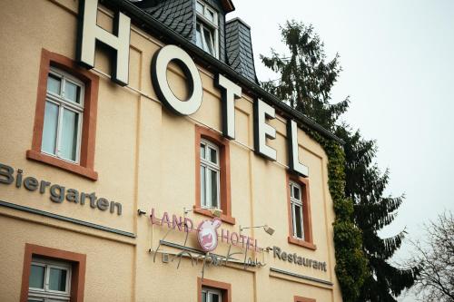 a hotel sign on the side of a building at Landhotel Airport-Inn in Lautzenhausen
