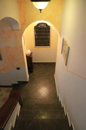 a hallway with a stairway with a window and a stair case at Locanda Miranda in Tellaro